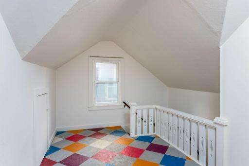 The upstairs hallway features a whimsical floor design that adds character to the landing, complemented by nostalgic wood railing and posts. Just makes you smile!