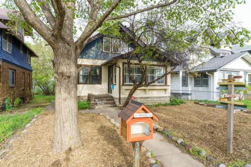 Charming stucco craftsman bungalow featuring a metal roof, solar panels and upper-level metal siding, along with your own "little library" and fresh mulch for a clean, refreshed curb appeal. Make this house your "home!"