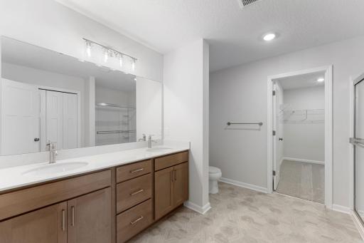 The owner’s en-suite offers a double-sink vanity and a seamless walk-through to the walk-in closet.