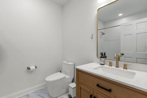 New lower level full bathroom with new vanity, sink and toilet, and ornate ceramic tile throughout!