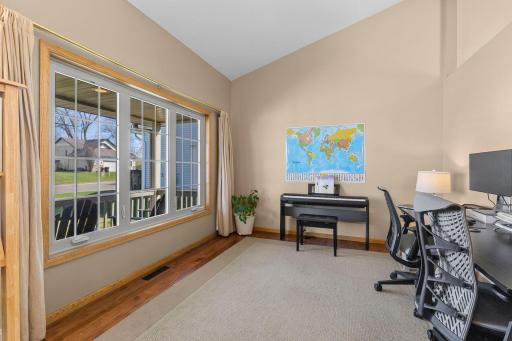 Main level living room that's currently being used as an office, with hardwood plank flooring throughout!