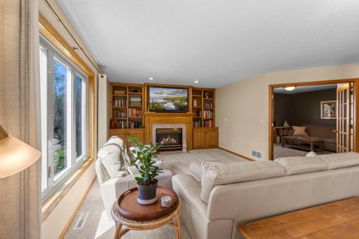 Spacious main level family room with a cozy gas fireplace and hardwood built-in's galore!