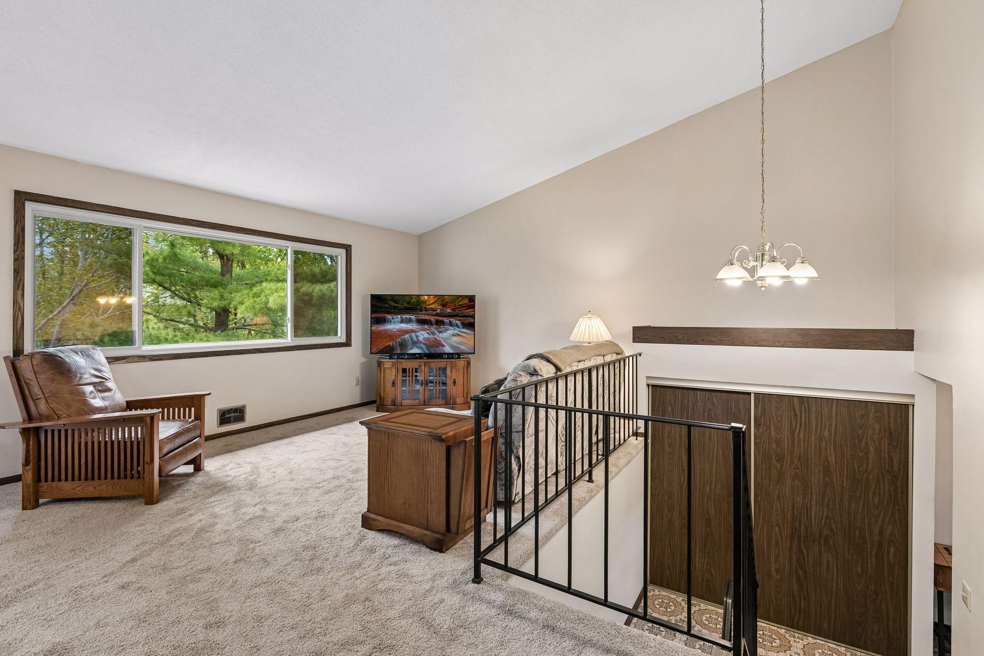 The living room is large and has a west facing picture window overlooking the private green space behind you.