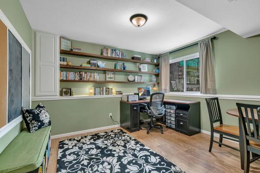 A spacious office with built-in shelves perfect for working from home, a craft room or kids play room.