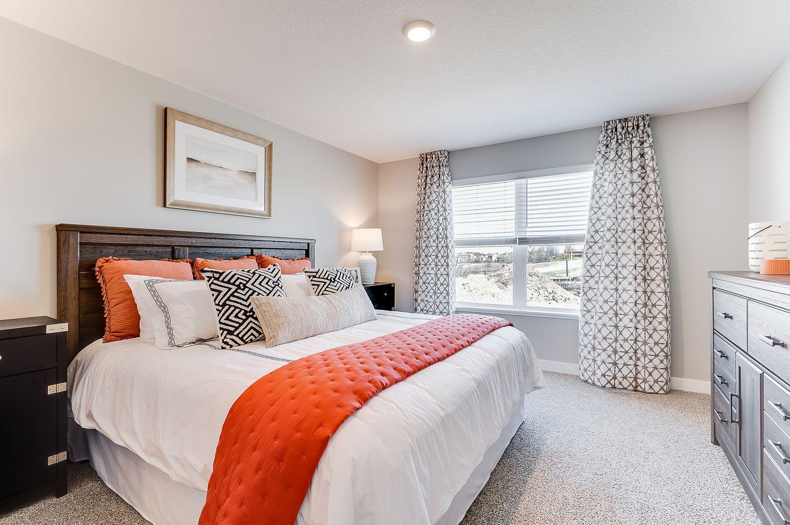 The primary bedroom is bright and open. (Model photo, colors may vary.)