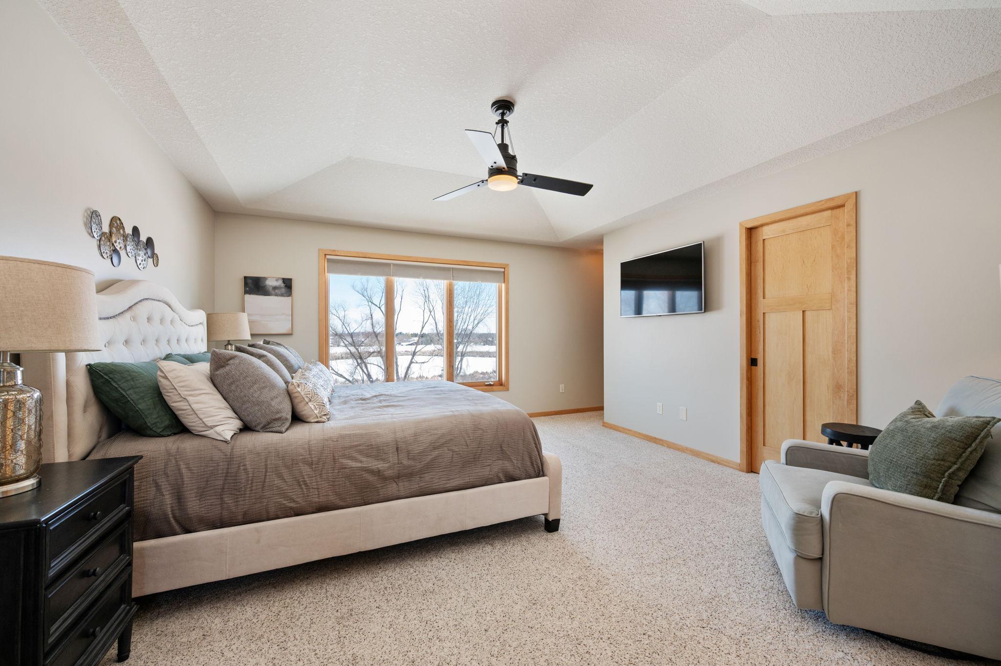 The primary bedroom is generous in space with a large walk-in closet with organizers and views of the back of the home. On the way to the bath is a built-in cabinet for display or more storage