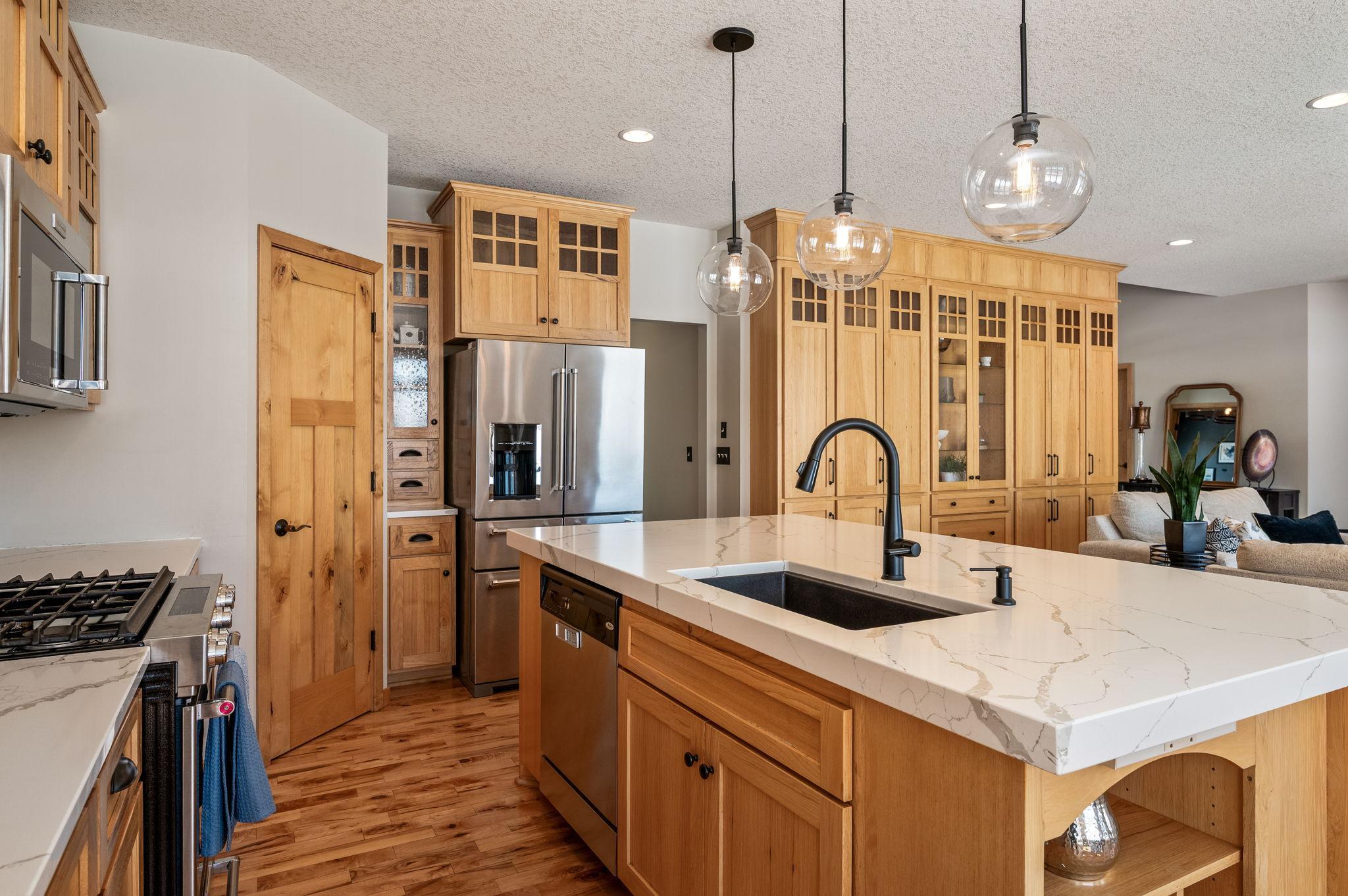 Newer stainless-steel appliances, walk in pantry, gas stove and granite sink makes this a kitchen to enjoy. Take a look at the thickness of the island quartz top, amazing!