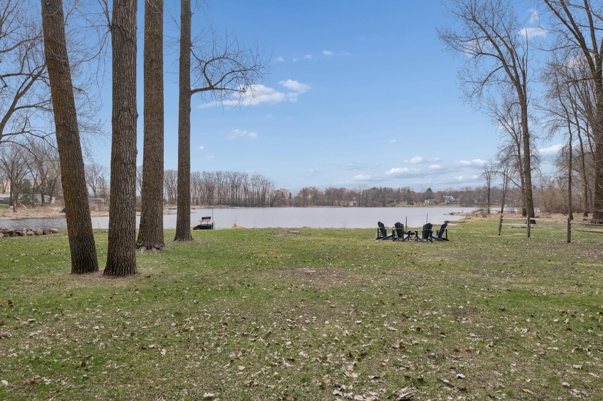 Large yard between the cabin and Pokegama with a firepit.