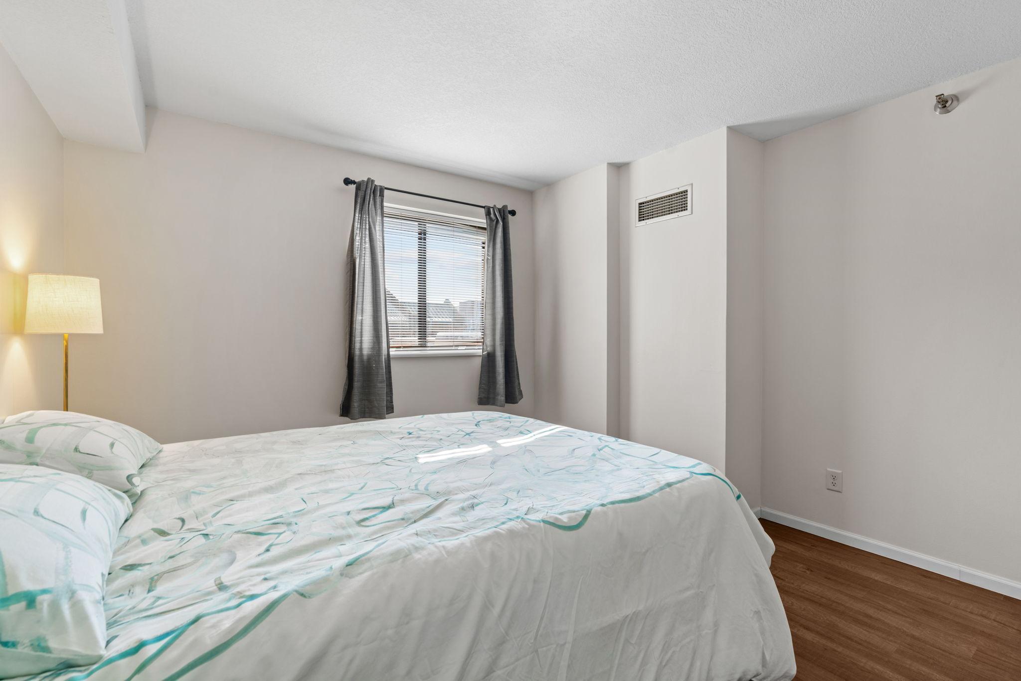 Bedroom with Window View of Rooftops