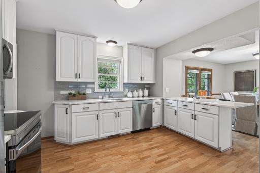 Thoughtfully updated kitchen with crisp white cabinetry and abundant prep space