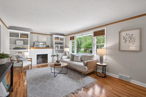 Light-filled living room with original hardwood floors and wood-burning fireplace