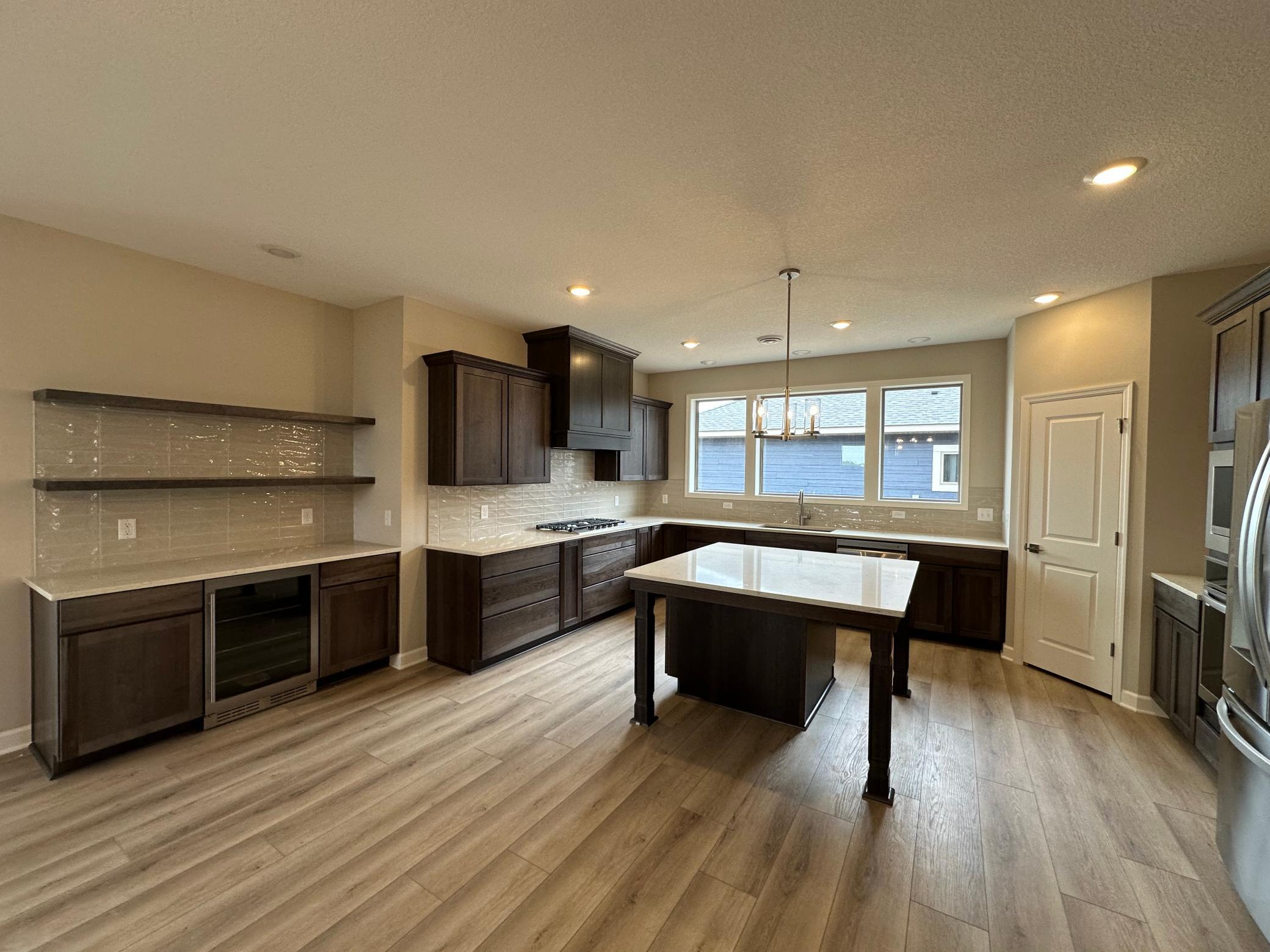 Professional Photos Coming Soon - This is a fantastic kitchen. Large center island with seating on two sides, load of perimeter countertop space, open storage above the beverage center for displaying dishes, and a large pantry.