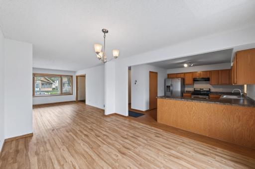 Dining space paired with kitchen, looking into the living room.