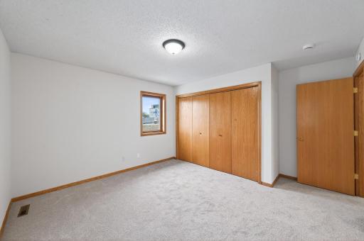 Primary bedroom from opposite view, showing the closet and entry door. Brand new carpet!