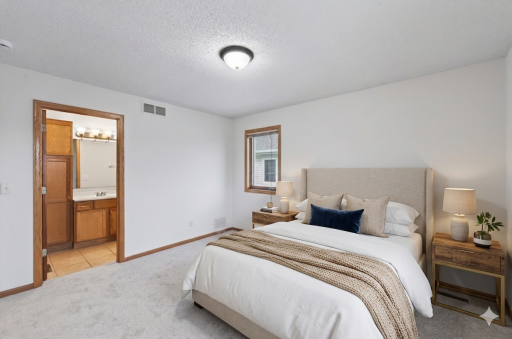 Primary bedroom on upper level features a full primary bathroom (photo virtually staged).