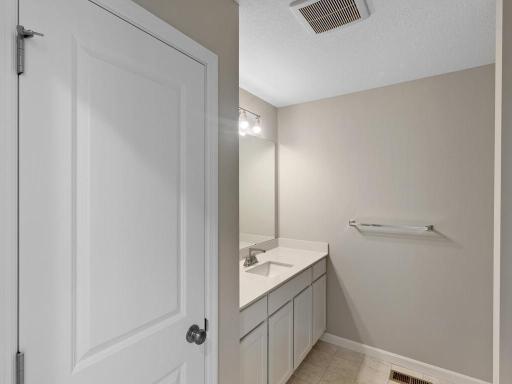 Main Level Bathroom. Photo taken of another home with similar plan and finishes. Photos and renderings may not depict actual plan, materials, & finishes may vary. All measurements are approximate.