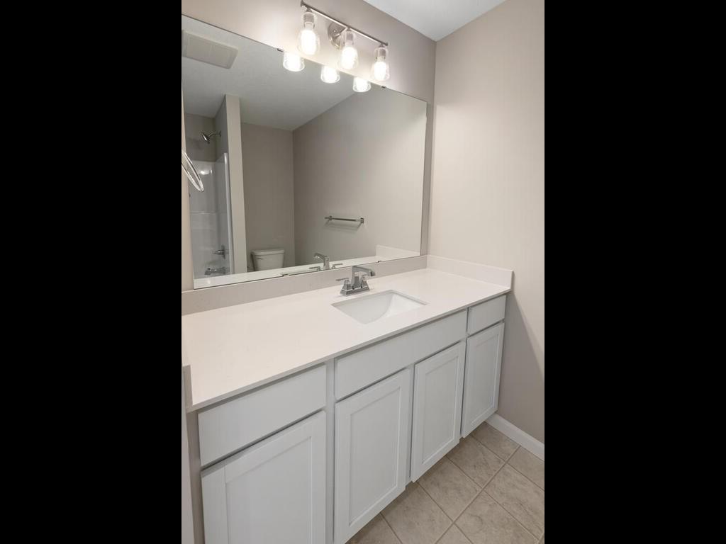 Main Level Bathroom. Photo taken of another home with similar plan and finishes. Photos and renderings may not depict actual plan, materials, & finishes may vary. All measurements are approximate.