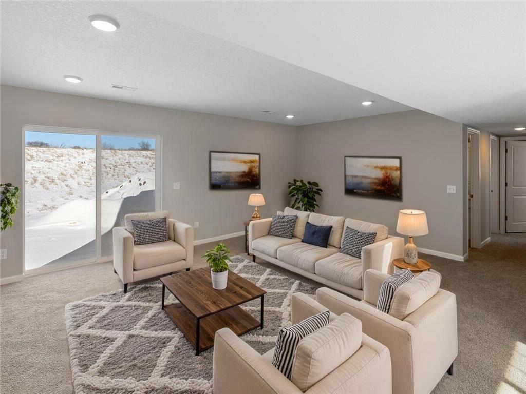 Finished Lower Level Family Room, Virtually Staged. Photo taken of another home with similar plan and finishes. Photos and renderings may not depict actual plan, materials, & finishes may vary. All measurements are approximate.