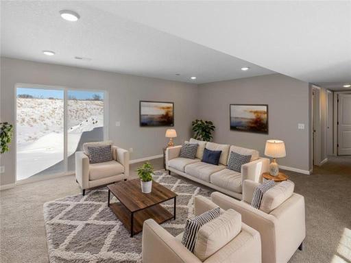 Finished Lower Level Family Room, Virtually Staged. Photo taken of another home with similar plan and finishes. Photos and renderings may not depict actual plan, materials, & finishes may vary. All measurements are approximate.