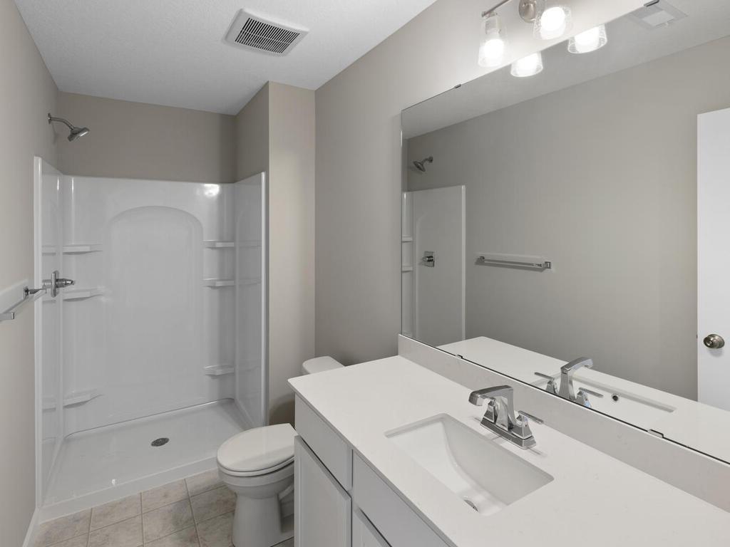 Finished Lower Level Bathroom. Photo taken of another home with similar plan and finishes. Photos and renderings may not depict actual plan, materials, & finishes may vary. All measurements are approximate.