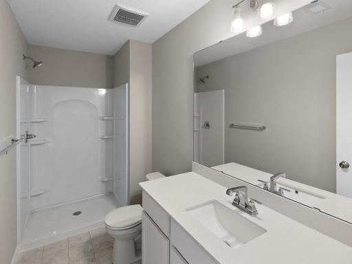 Finished Lower Level Bathroom. Photo taken of another home with similar plan and finishes. Photos and renderings may not depict actual plan, materials, & finishes may vary. All measurements are approximate.