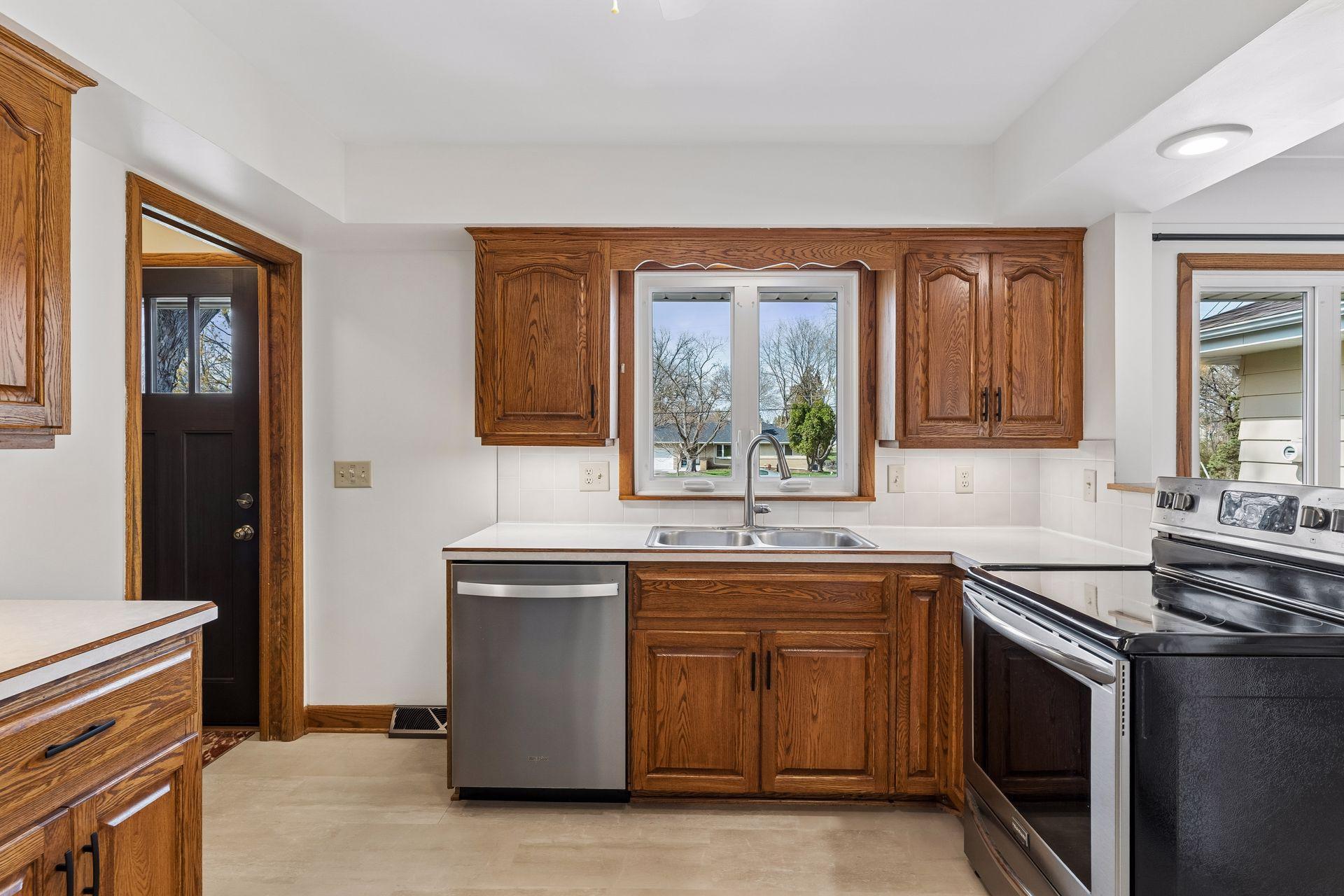 12x11 Kitchen with Oak cabinets, new vinyl flooring, fresh paint, and stainless steel appliances. North-facing windows.