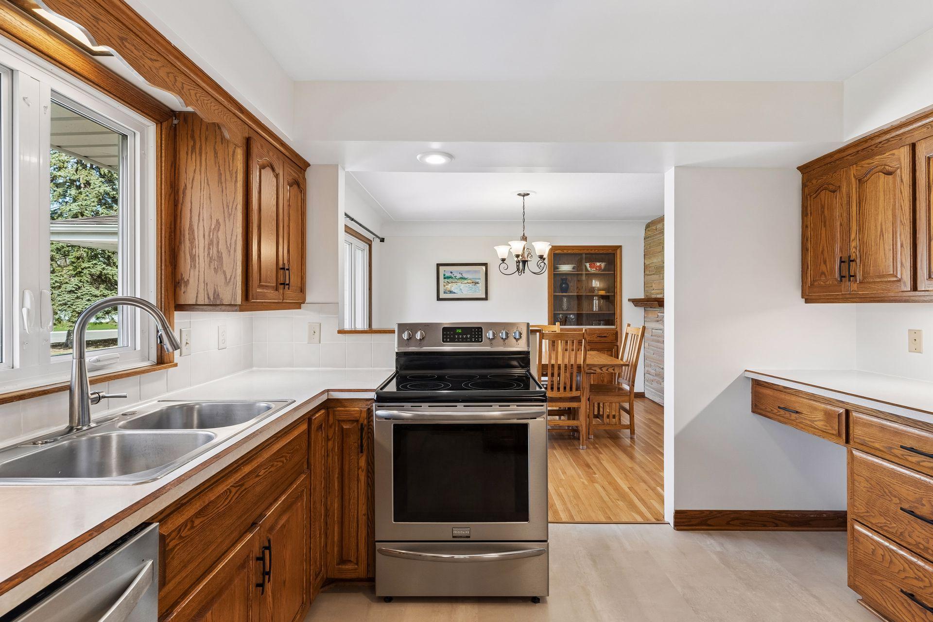 12x11 Kitchen with Oak cabinets, new vinyl flooring, fresh paint, and stainless steel appliances. North-facing windows.