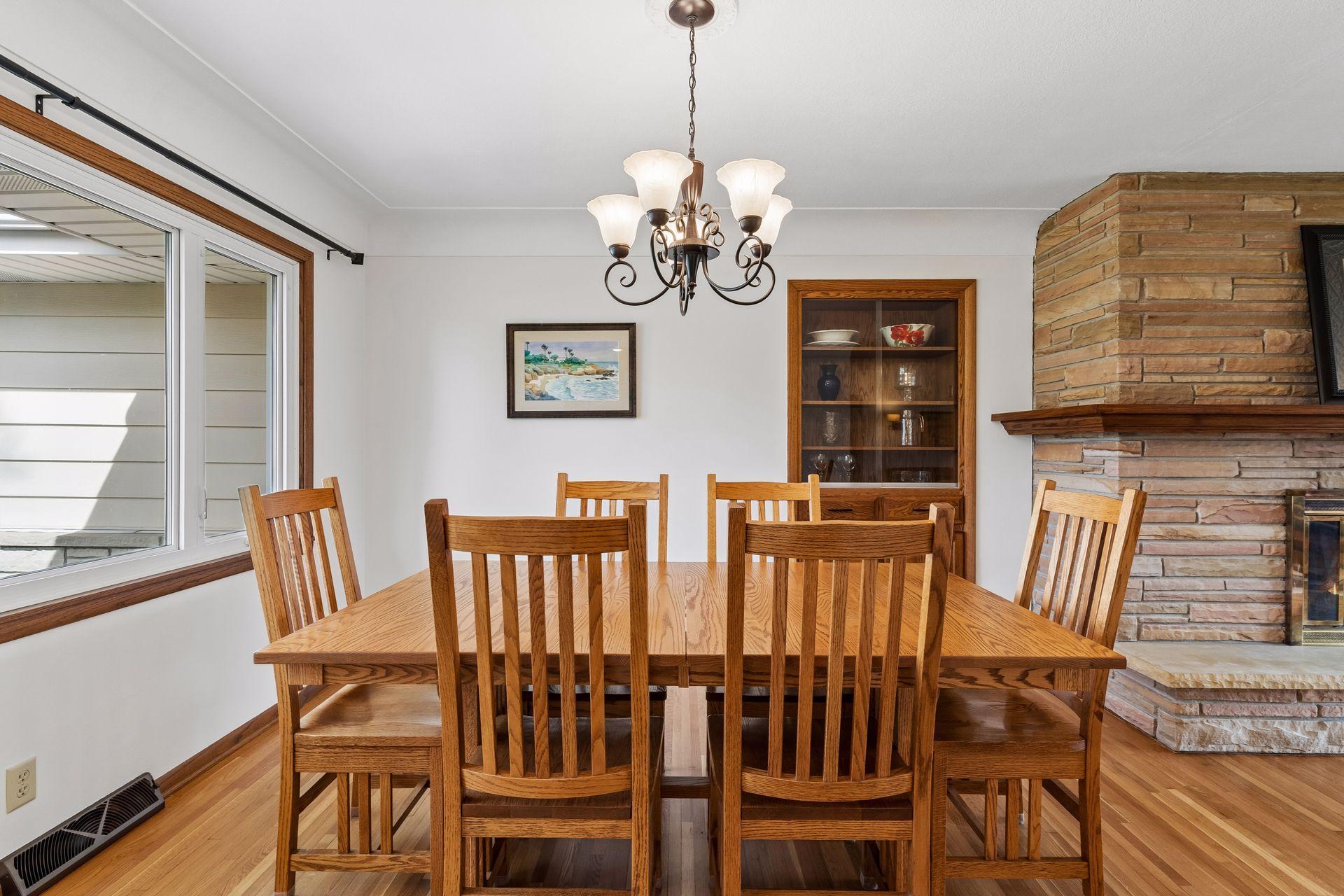 13x12 Main floor Dining room with freshly refinished oak hardwood floors, updated north-facing windows, and a 2-sided fireplace.