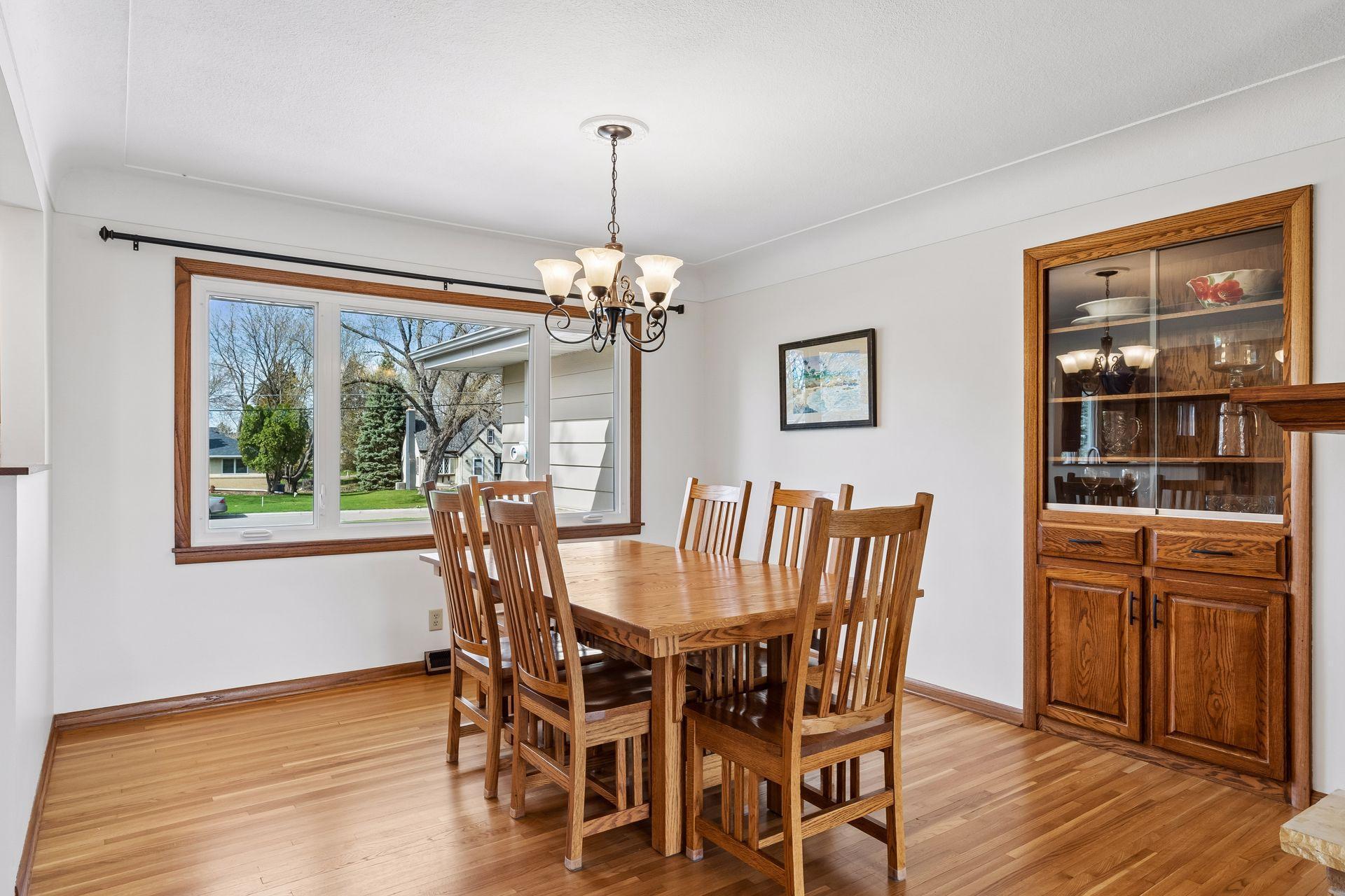 13x12 Main floor Dining room with freshly refinished oak hardwood floors, updated north-facing windows, and a 2-sided fireplace.