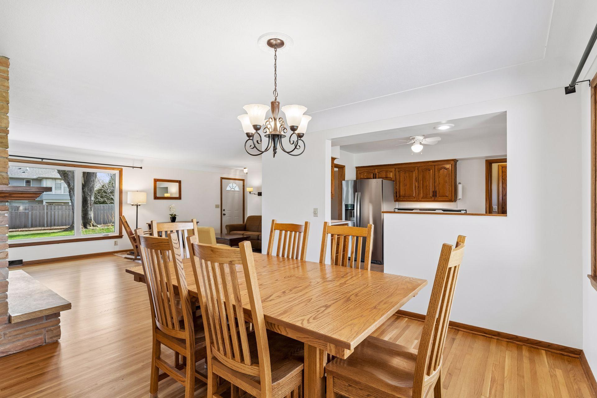 13x12 Main floor Dining room with freshly refinished oak hardwood floors, updated north-facing windows, and a 2-sided fireplace.