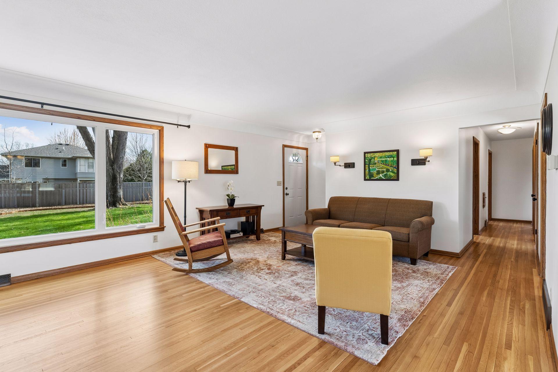 21x15 Main floor Living room with freshly refinished oak hardwood floors, new paint, updated south-facing windows, and a 2-sided fireplace.