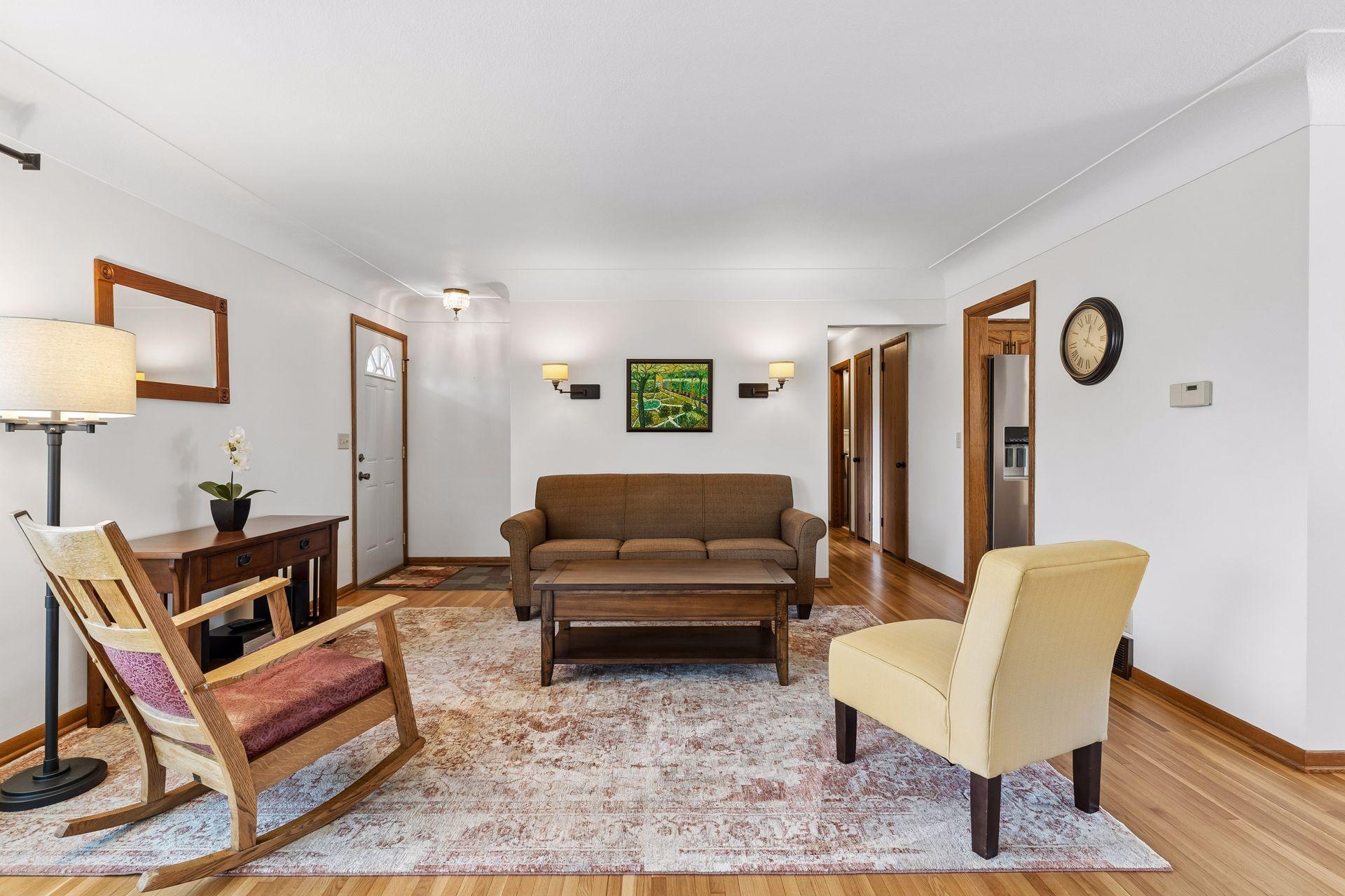 21x15 Main floor Living room with freshly refinished oak hardwood floors, new paint, updated south-facing windows, and a 2-sided fireplace.