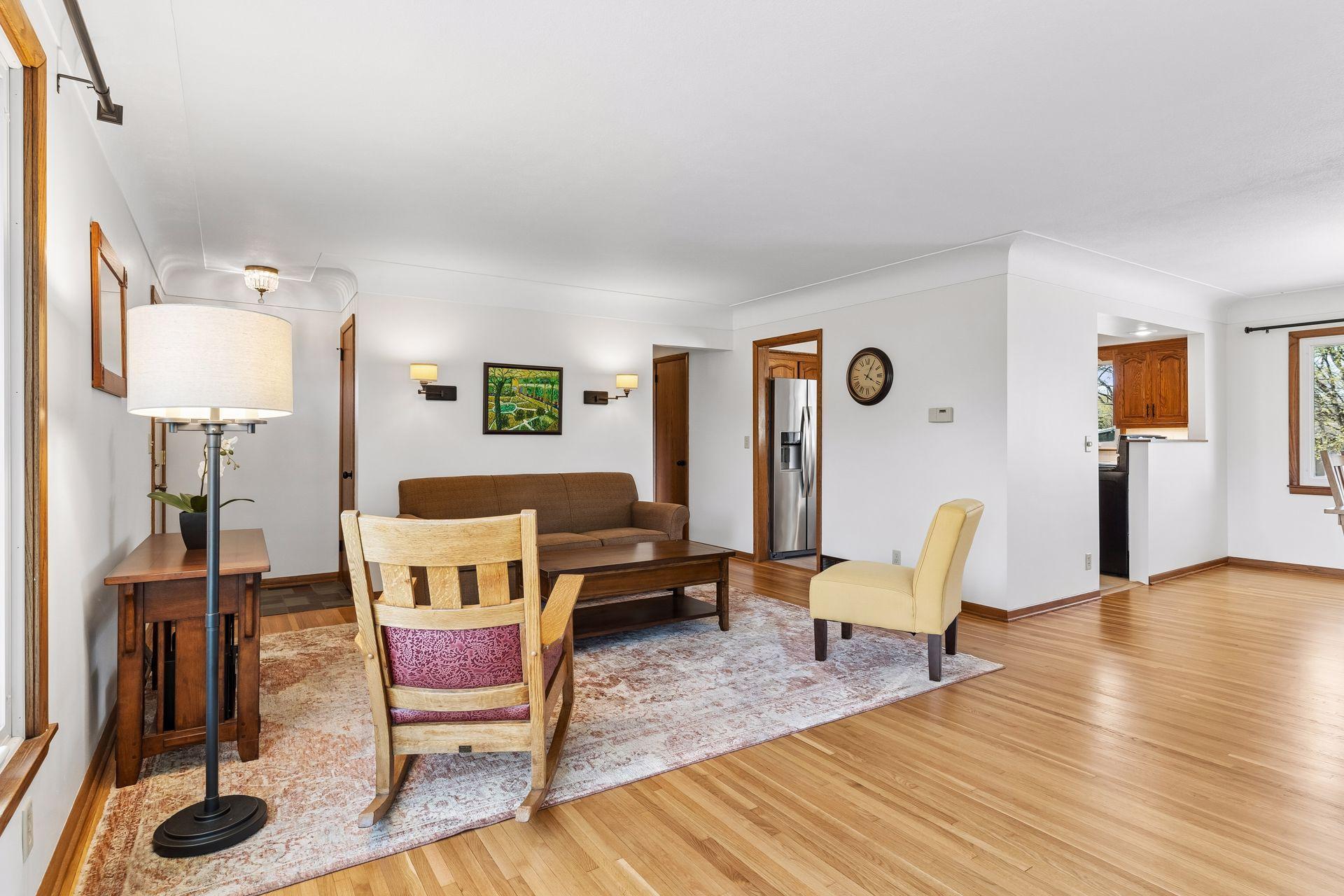 21x15 Main floor Living room with freshly refinished oak hardwood floors, new paint, updated south-facing windows, and a 2-sided fireplace.