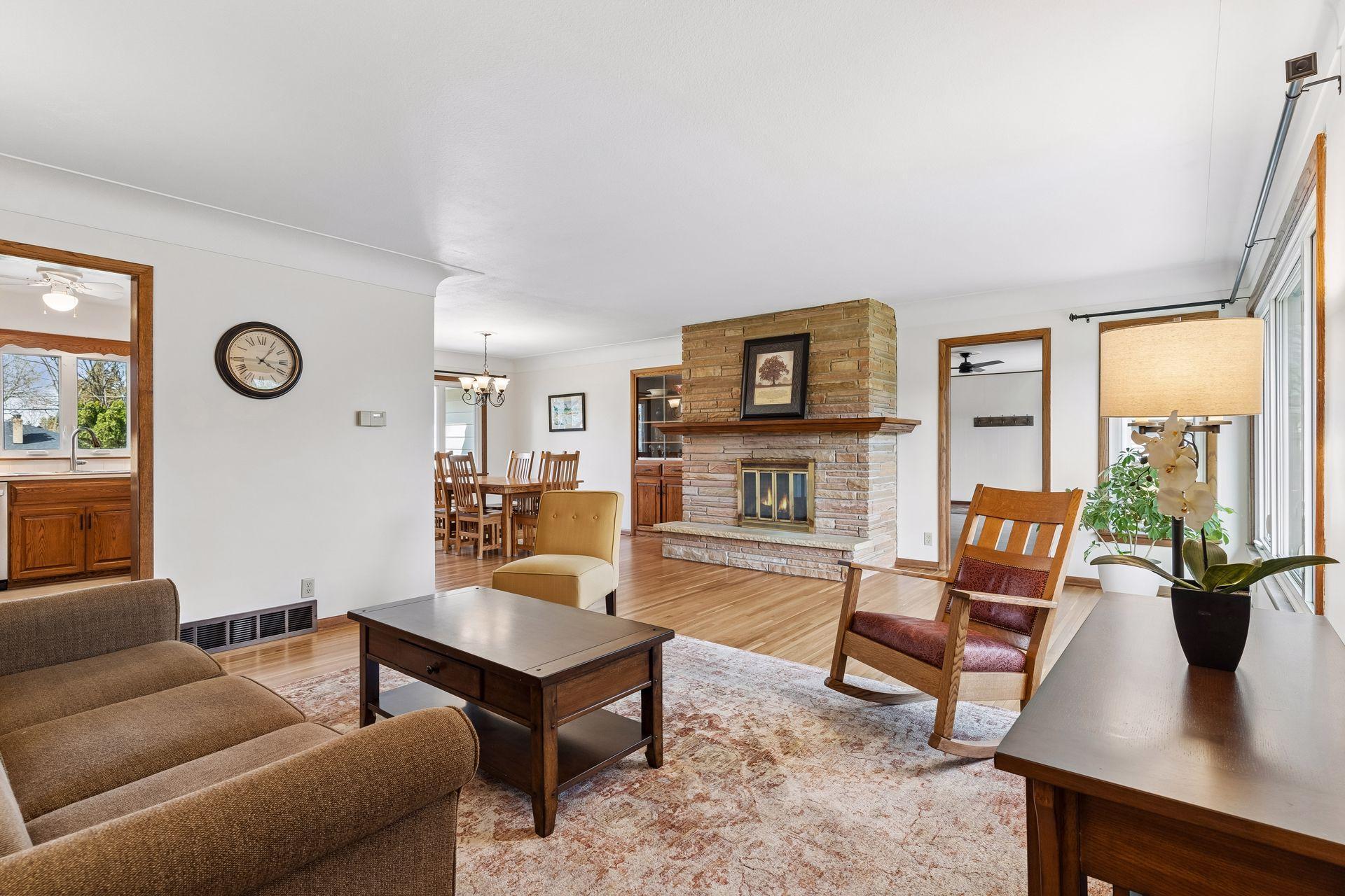 21x15 Main floor Living room with freshly refinished oak hardwood floors, new paint, updated south-facing windows, and a 2-sided fireplace.