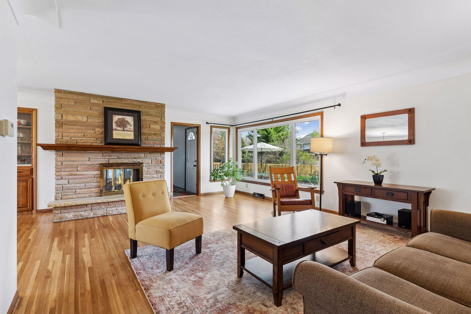 21x15 Main floor Living room with freshly refinished oak hardwood floors, new paint, updated south-facing windows, and a 2-sided fireplace.
