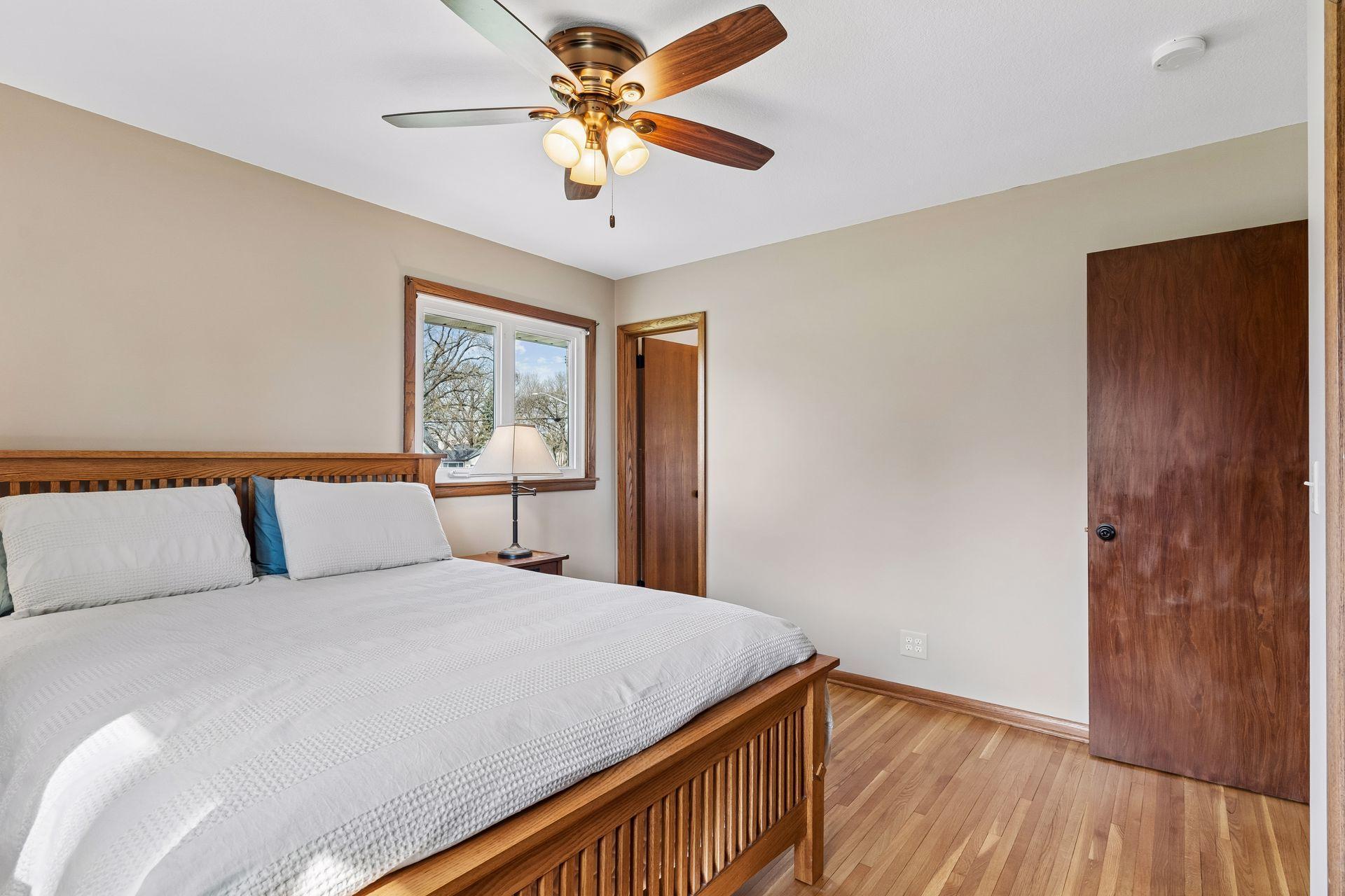 12x12 Main floor Bedroom #1 with freshly refinished oak hardwood floors, new paint, hardwood trim, updated west and north-facing windows, and attached Half Bathroom.