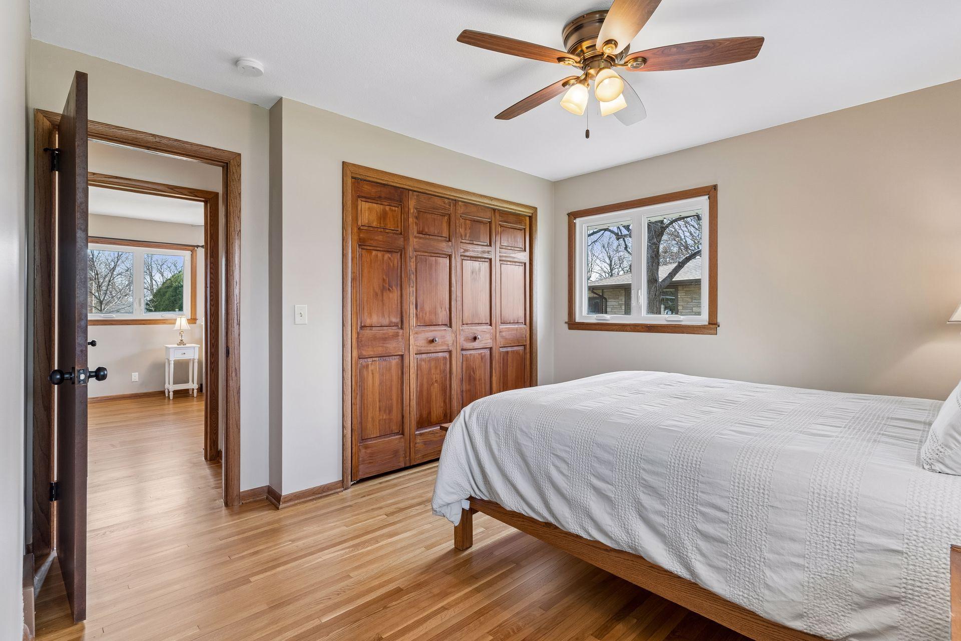 12x12 Main floor Bedroom #1 with freshly refinished oak hardwood floors, new paint, hardwood trim, updated west and north-facing windows, and attached Half Bathroom.