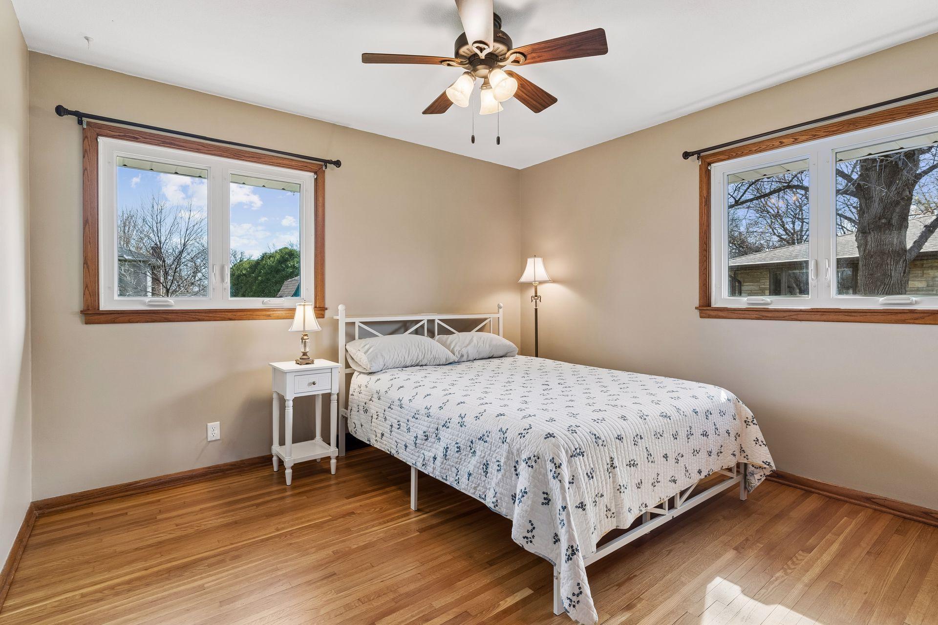 12x12 Main floor Bedroom #2 with freshly refinished oak hardwood floors, new paint, hardwood trim, updated west and south-facing windows.