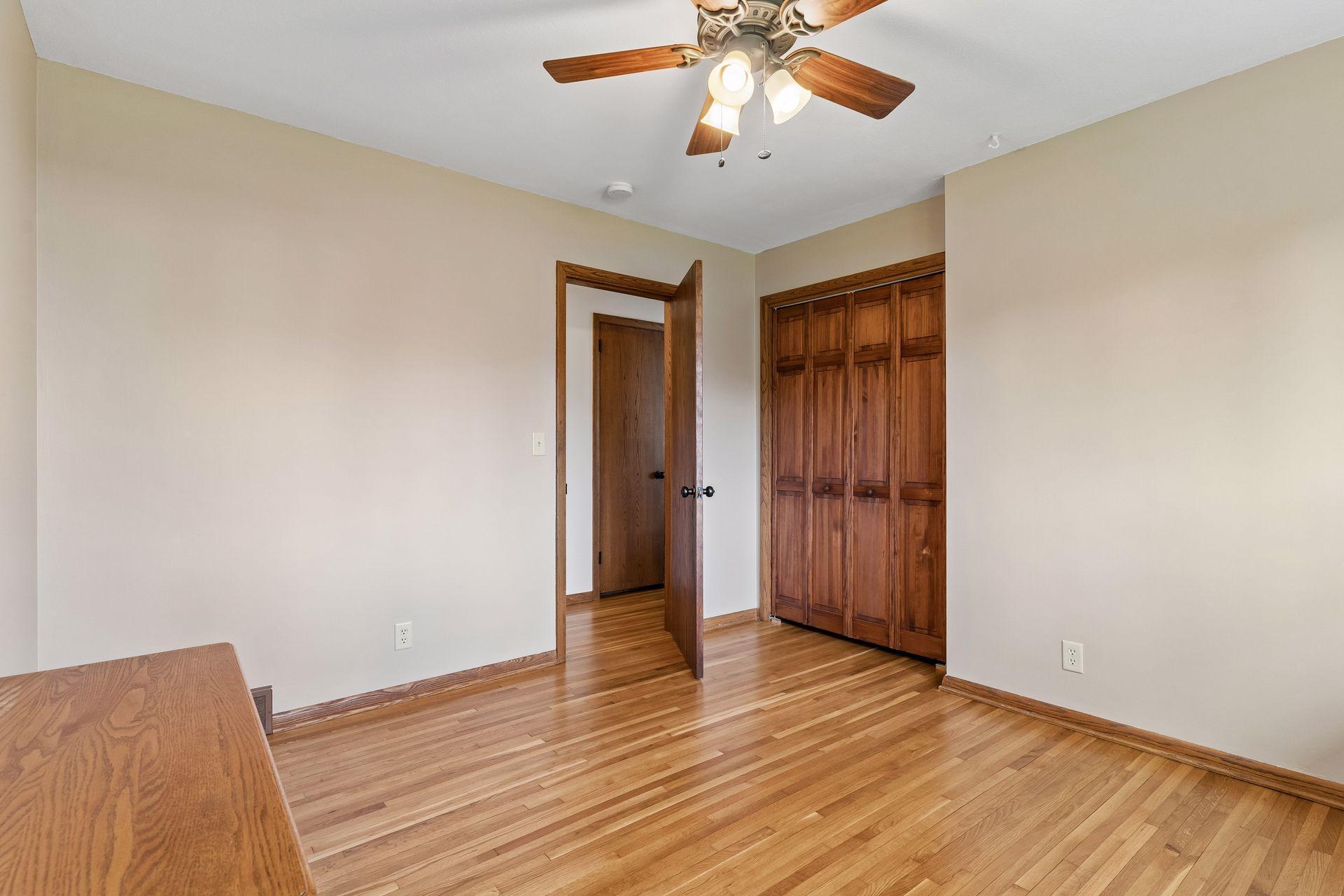 12x11 Main floor Bedroom #3 with freshly refinished oak hardwood floors, new paint, hardwood trim, updated south-facing windows.