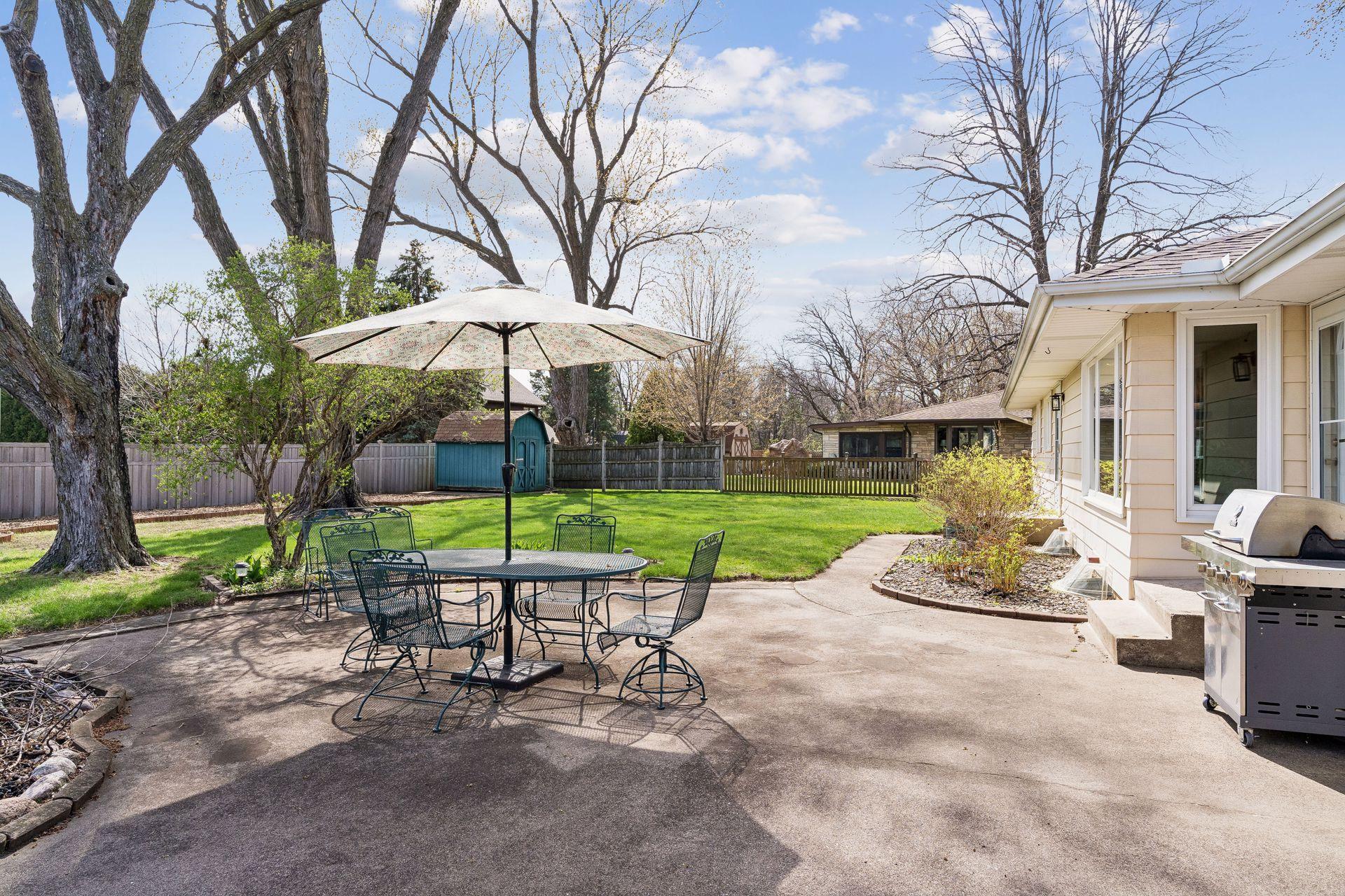 South-facing concrete backyard patio, Storage shed, and a wood fence.