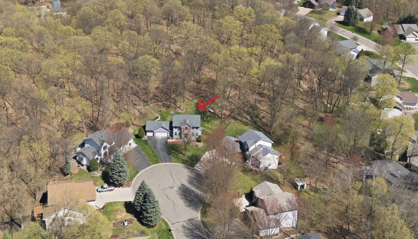 Aerial view shows the quiet cul-de-sac location and wooded privacy provided by the wooded backyard.