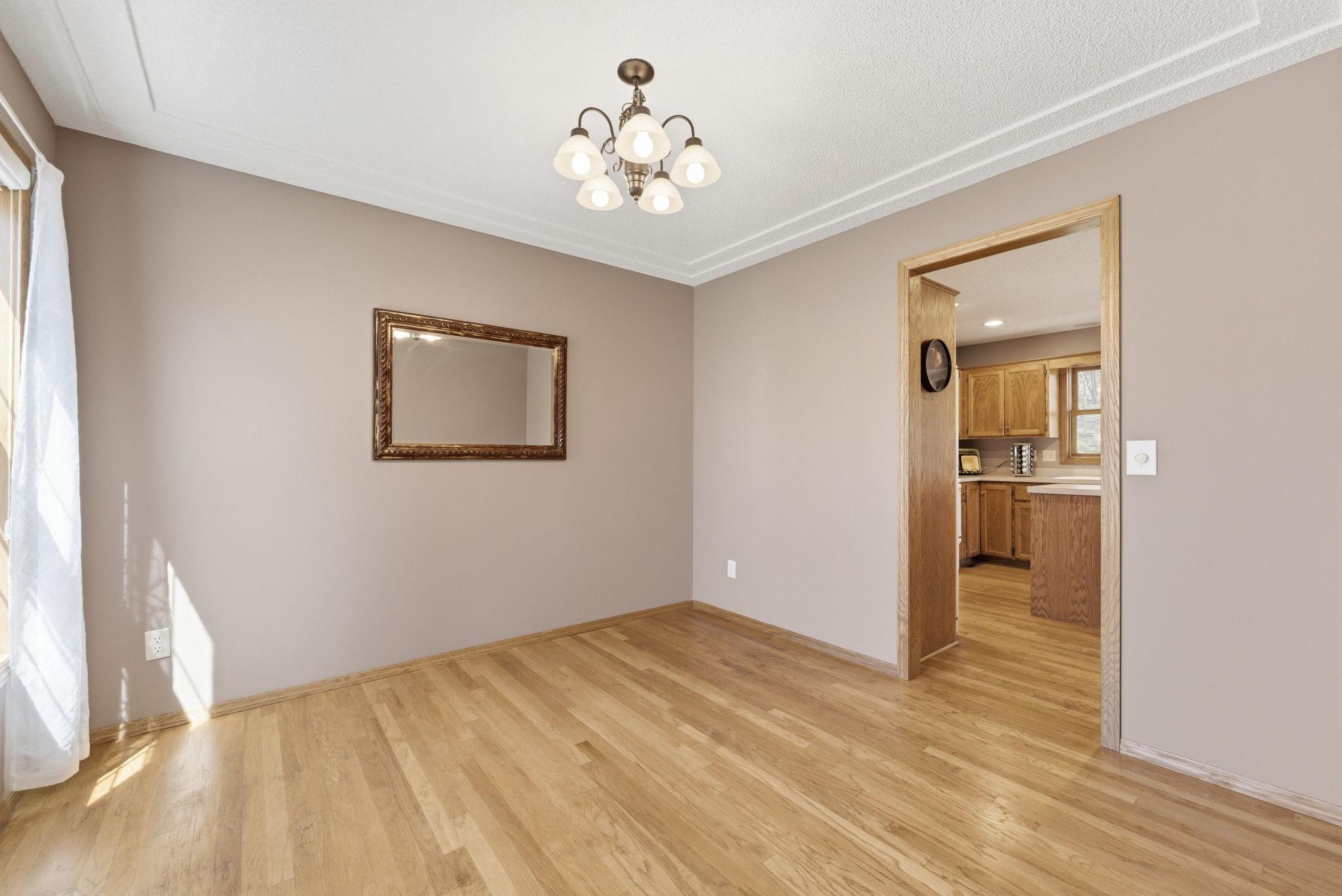 Main level flex room located just off the kitchen boasts real hardwood floors.