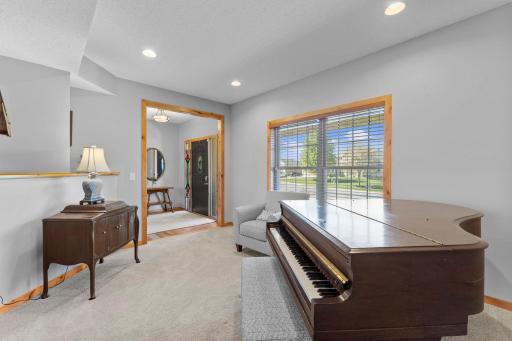 This inviting room features carpeting, recessed lighting, and a large window that showcases peaceful neighborhood views while filling the space with natural light.