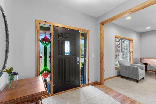Inside, a welcoming foyer opens to stunning hardwood floors, newly installed in 2024, which extend throughout the kitchen and dining area.