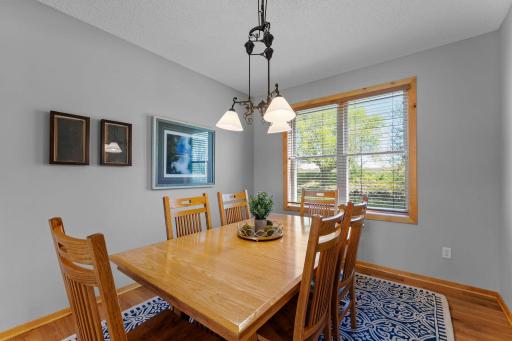 Adjacent to the kitchen, the dining room is highlighted by a classic chandelier and a large rear-facing window that fills the space with natural light.