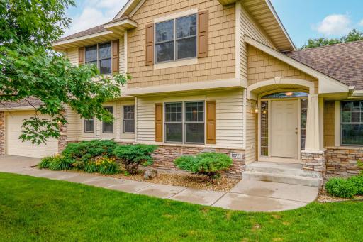 A warm and welcoming front entrance highlighted by attractive stone accents, manicured landscaping, and a covered entryway.