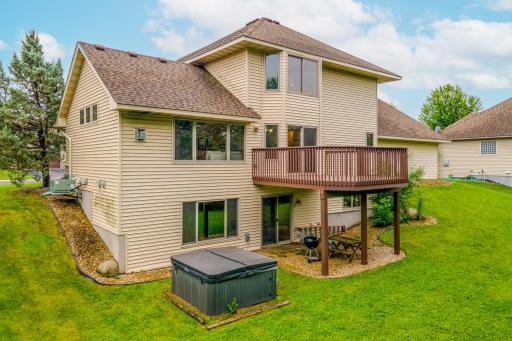 Enjoy outdoor living with an elevated deck, lower-level patio space, and a relaxing hot tub overlooking the backyard.