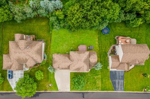 Birdâs-eye view showcasing the homeâs generous lot, mature trees, and established neighborhood surroundings.