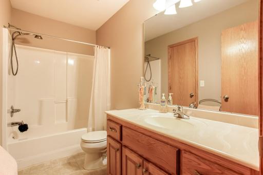 Well-maintained full walk-thru bathroom features a spacious vanity, ample counter space, and a tub/shower combination.
