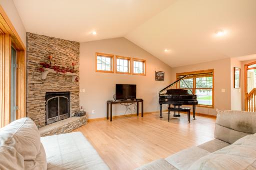 A dramatic stone-surround fireplace serves as the focal point of this warm and welcoming gathering space.